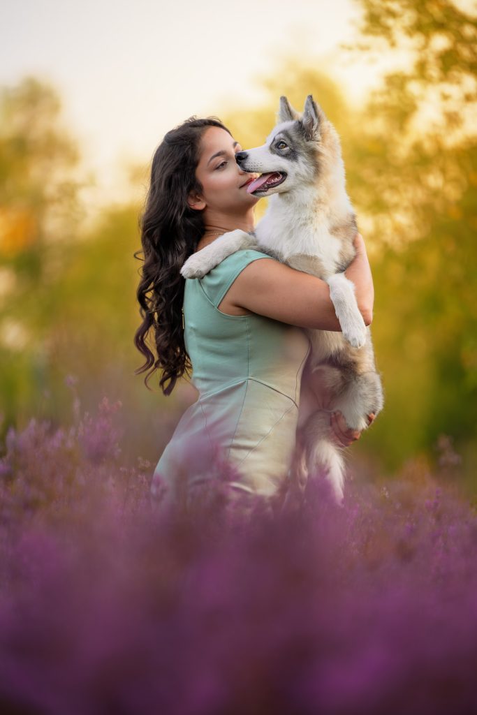 Portrait d'une humaine portant son chien avec un regard tendre